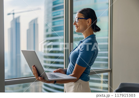 A Professional Woman Engaged in Work on Her Laptop Within a Stylish Modern Office Environment A Professional Woman Engaged in Work on Her Laptop Within a Stylish Modern Office Environment 117915303