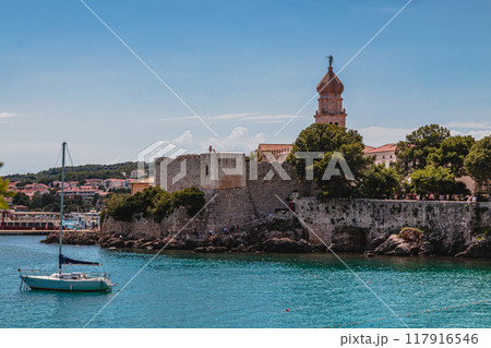 Krk Croatia 26.06.24 Boats on little port beside old town view with vegetation 117916546