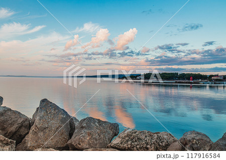 Krk Croatia 27.06.24The stone shore of the bay on the background of the old town 117916584