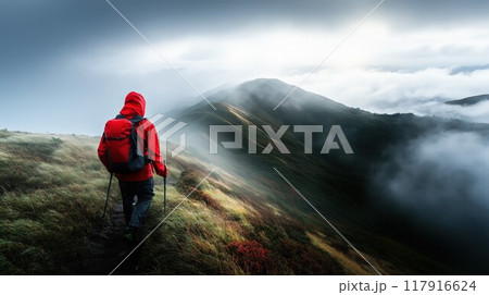 霧の中、山をトレッキングする男性 117916624