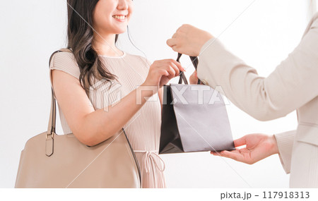 高級店で紙袋・商品を受け取る買い物客の女性（デパート・百貨店・ブランド品） 117918313
