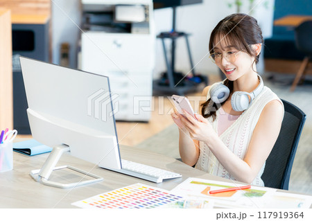 オフィスでスマホを持つビジネスウーマン オフィスでスマホを持つビジネスウーマン 117919364