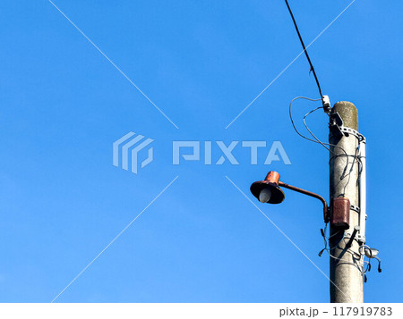 春の青空と電柱に取り付けられた古い街灯 117919783