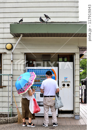 不忍池ボート乗り場入口自販機でジュースを買う二人 117919843