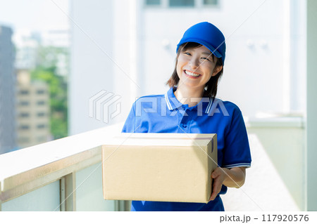 荷物を届ける宅配便の女性ドライバー 117920576
