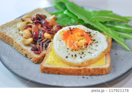 bread with egg and cheese topping or  sunny side up egg , lettuce and almond with dried cranberry and milk 117921178