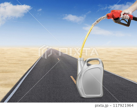 Hold the gasoline injector into the gallon. There are road and desert backgrounds. 117921964