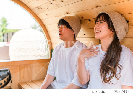 サウナに入っているTシャツ姿のカップルの若い男女 サウナに入っているTシャツ姿のカップルの若い男女 117922495