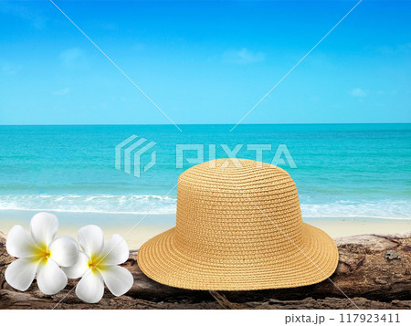 Vintage hat, wooden icon, flowers and tropical sea background. summer paradise cruise travel design tourism, beach, holiday travel destination concept Vintage hat, wooden icon, flowers and tropical sea background. summer paradise cruise travel design tourism, beach, holiday travel destination concept 117923411