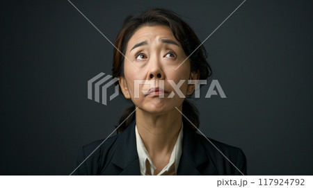 上を見上げるスーツを着た中年の女性 117924792