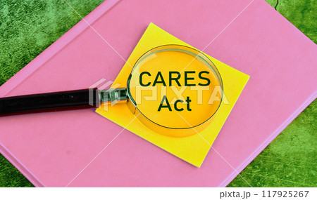 The Coronavirus Aid, Relief, and Economic Security Act. A word CARES act on a yellow sticker through a magnifying glass The Coronavirus Aid, Relief, and Economic Security Act. A word CARES act on a yellow sticker through a magnifying glass 117925267