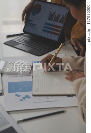 Close up of Business team analyzing income charts and graphs with modern laptop computer. Business analysis and strategy concept. 117926000