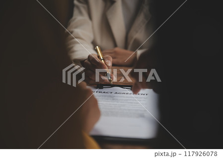 Business and lawyers discussing contract papers with brass scale on desk in office. Law, legal services, advice, justice and law concept picture with film grain effect Business and lawyers discussing contract papers with brass scale on desk in office. Law, legal services, advice, justice and law concept picture with film grain effect 117926078