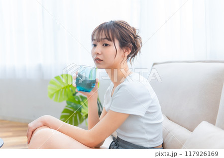 ソファでくつろぐ部屋着の女性/休日の朝/リラックス ソファでくつろぐ部屋着の女性/休日の朝/リラックス 117926169