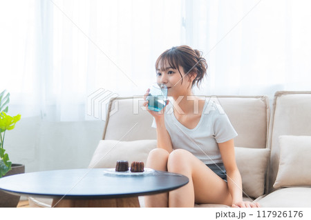 ソファでくつろぐ部屋着の女性/休日の朝/リラックス ソファでくつろぐ部屋着の女性/休日の朝/リラックス 117926176