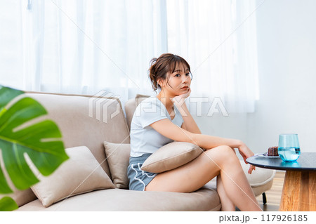 ソファでくつろぐ部屋着の女性/休日の朝/リラックス ソファでくつろぐ部屋着の女性/休日の朝/リラックス 117926185