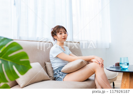 ソファでくつろぐ部屋着の女性/休日の朝/リラックス ソファでくつろぐ部屋着の女性/休日の朝/リラックス 117926187