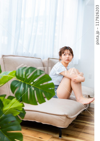 ソファでくつろぐ部屋着の女性/休日の朝/リラックス 117926203