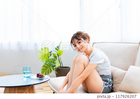 ソファでくつろぐ部屋着の女性/休日の朝/リラックス ソファでくつろぐ部屋着の女性/休日の朝/リラックス 117926207