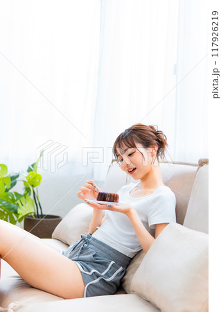 ソファでくつろぐ部屋着の女性/休日の朝/リラックス 117926219