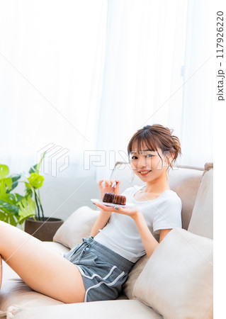 ソファでくつろぐ部屋着の女性/休日の朝/リラックス 117926220