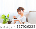 ソファでくつろぐ部屋着の女性/休日の朝/リラックス 117926223