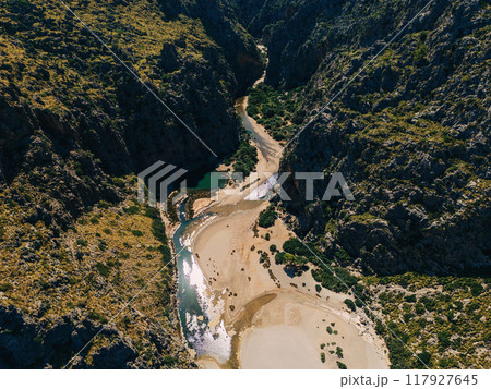 Aerial view of a winding river flowing through a deep canyon. Sa Calobra 117927645