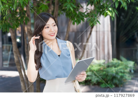 オフィス街でタブレット端末を持つビジネスウーマン 117927869