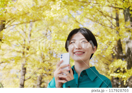 秋の紅葉を撮影する若い女性 117928703