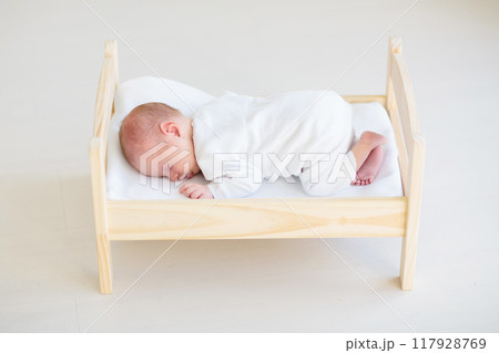 Little baby on toy bed Little baby on toy bed 117928769