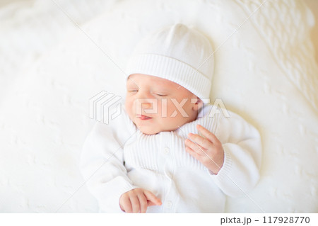 Little baby on white bed 117928770