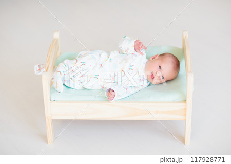 Little baby on toy bed 117928771