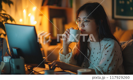 young woman working on laptop at night office 117929260