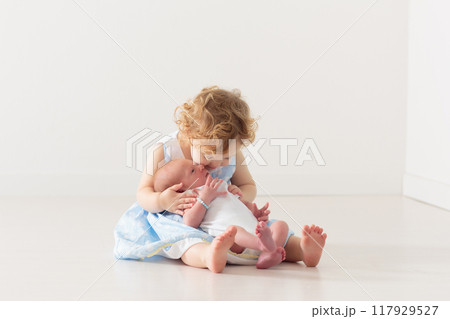 Siblings meet newborn baby Siblings meet newborn baby 117929527