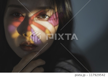 ステンドグラスの光を浴びる女性 117929542