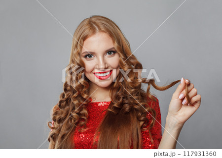 Cheerful woman fashion model with bright make-up, shiny clear skin and long healthy curly hairstyle 117931360