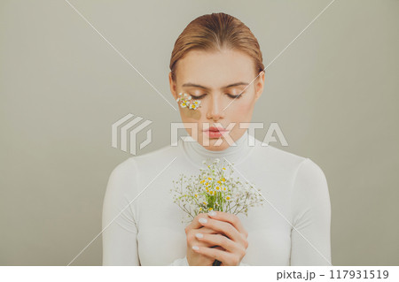 Pretty young woman with wild flowers portrait 117931519