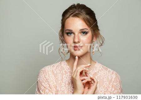 Charming adorable woman wearing pink lace blouse. Model with make-up and updo hair, beautiful hairdo Charming adorable woman wearing pink lace blouse. Model with make-up and updo hair, beautiful hairdo 117931630