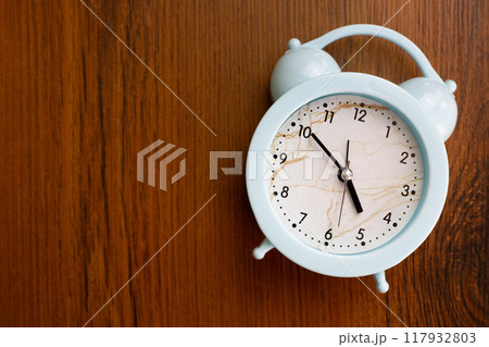Alarm clock lies on wooden shelf, device for waking person after sleep, healthy and deep sleep and rise at the right time Alarm clock lies on wooden shelf, device for waking person after sleep, healthy and deep sleep and rise at the right time 117932803