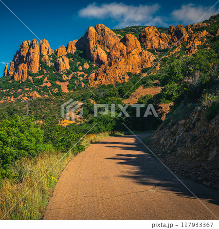 Hiking trail and red rocks in the Esterel massif, France Hiking trail and red rocks in the Esterel massif, France 117933367