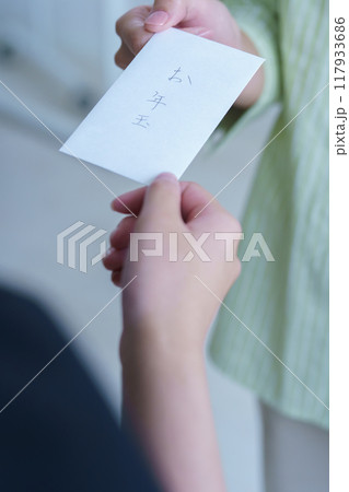 心付けに間に合わせのおとしだまを渡す若い女性 117933686