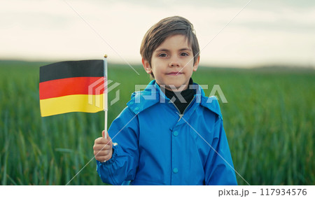 German little boy stands with Deutschland national flag. Patriotism. Black, red and yellow colors of 117934576