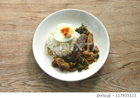 spicy str fried slice mackerel with chili and basil on rice topping boiled egg dressing chili garlic fish sauce in plate spicy str fried slice mackerel with chili and basil on rice topping boiled egg dressing chili garlic fish sauce in plate 117935121