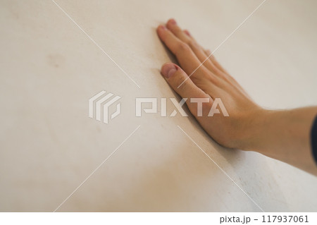 closeup young man hand touching plastered wall closeup young man hand touching plastered wall 117937061