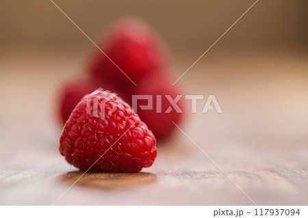 Ripe raspberries on wood background 117937094