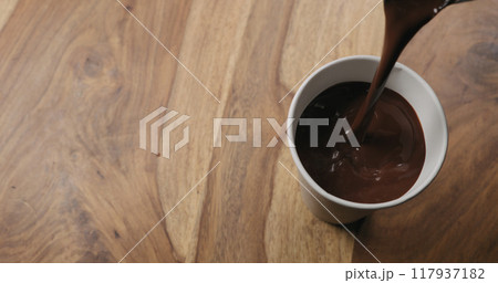 pour hot cocoa in paper cup on wood background with copy space pour hot cocoa in paper cup on wood background with copy space 117937182