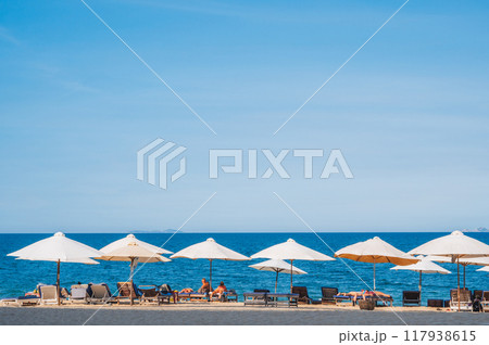 beach umbrellas with sun beds on a sandy beach against the background of the sea and ocean beach umbrellas with sun beds on a sandy beach against the background of the sea and ocean 117938615