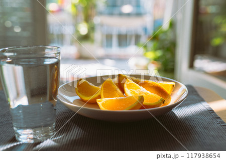 peeled oranges and glass water on table peeled oranges and glass water on table 117938654