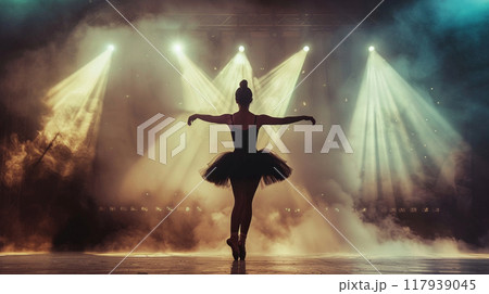 Professional ballerina dancing ballet in spotlights smoke on big stage. Beautiful young girl wearing black tutu dress on floodlights background 117939045