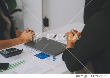 Financial analysts analyze business financial reports on a digital tablet planning investment project during a discussion at a meeting of corporate showing the results of their successful teamwork. 117939966